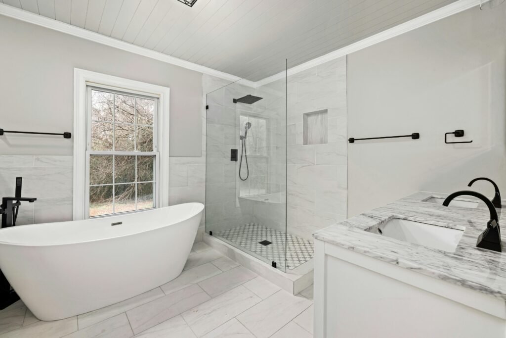 Sleek bathroom featuring a freestanding tub, glass shower, and marble accents.